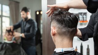 Friseur schneidet einem Mann die Haare.
