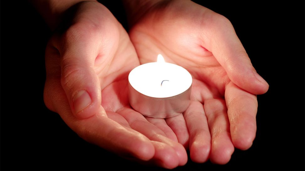 Eine brennende Kerze wird von einer Hand gehalten. (Bild: Colourbox)