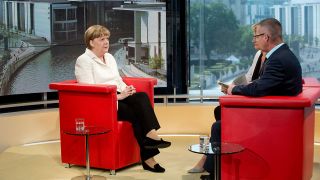Bundeskanzlerin Angela Merkel (CDU) lässt sich beim Sommerinterview von den Journalisten Tina Hassel und Rainald Becker interviewen © dpa
