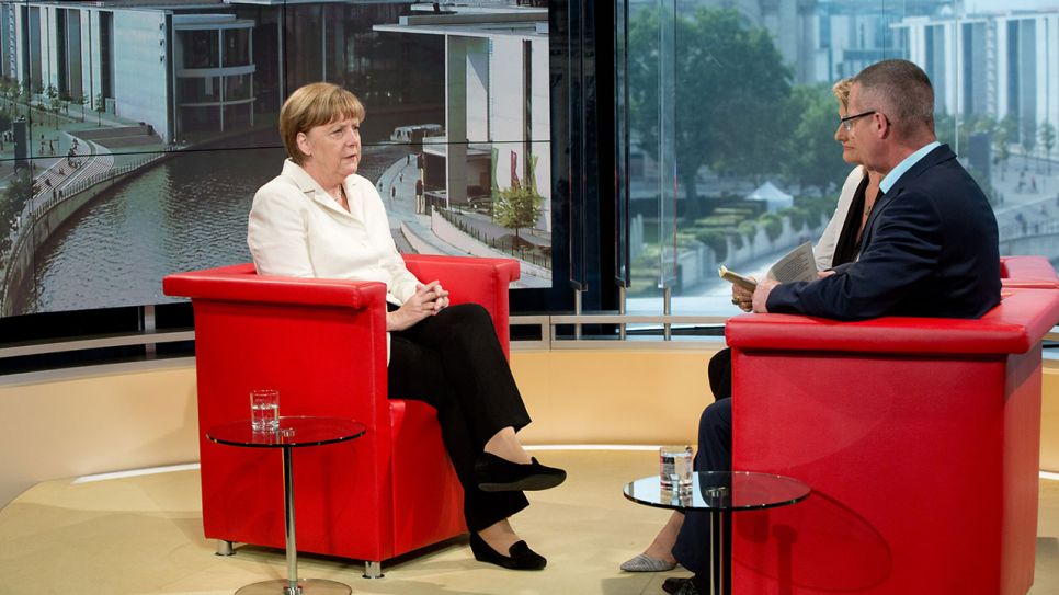 Bundeskanzlerin Angela Merkel (CDU) lässt sich beim Sommerinterview von den Journalisten Tina Hassel und Rainald Becker interviewen © dpa