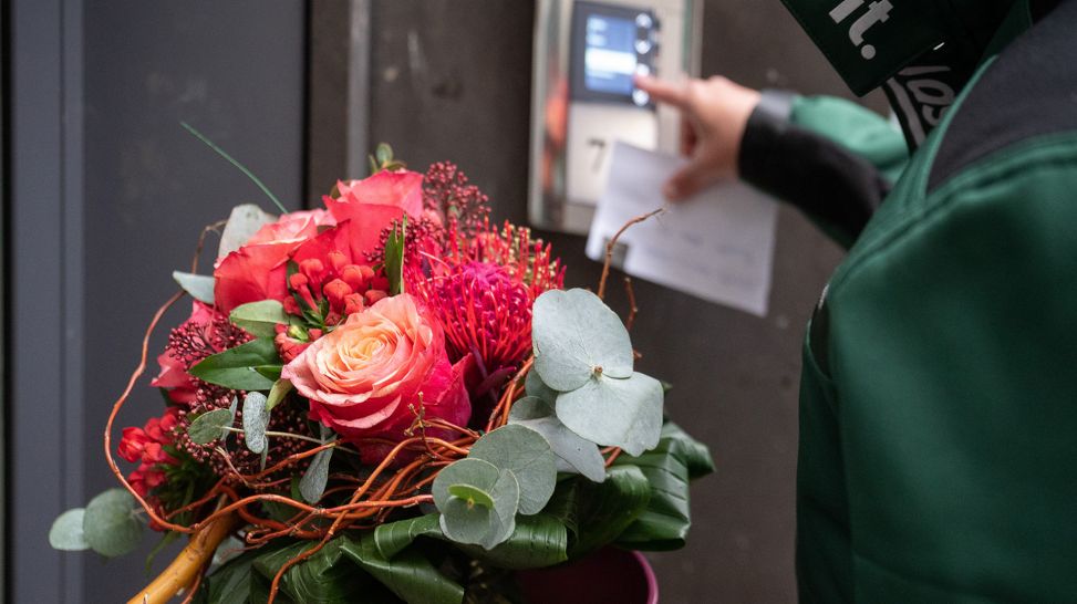 Lieferant mit Blumenstrauß im Fahrstuhl (Quelle: picture alliance/dpa|Sebastian Gollnow)