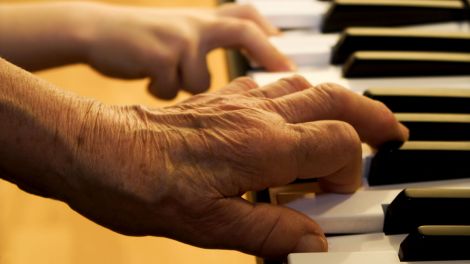 hands of old piano player and grandchild (Quelle: Adobe Stock)