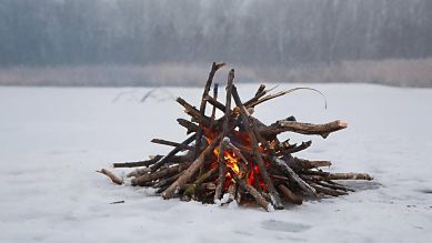 Lagerfeuer auf schneebedecktem See (Bild: imago images)