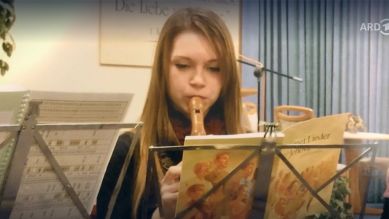 Kinderfoto: Sophie spielt Flöte nach religiösem Liederbuch (Bild: ARD Mediathek)