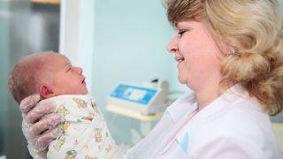 Hebamme mit Neugeborenem, Quelle: colourbox