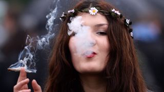 Junge Frau konsumiert Cannabis. Bild: Andy Rain/EPA