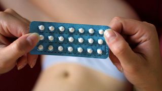 Frau hält Packung einer Anti-Baby-Pille in der Hand (Quelle: colourbox)