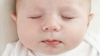 Schlafendes Baby mit leicht abstehenden Ohren (Quelle: imago/Science Photo Library)