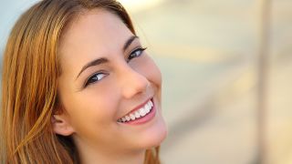 Frau lächelt mit weißen Zähnen (Quelle: Colourbox)
