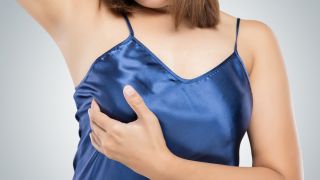 Brustwarzen schmerzen, Frau befühlt ihre rechte Brust mit der Hand (Quelle: Colourbox)