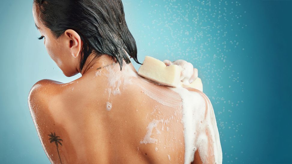 Pflege und Gefahr für die Haut: Frau mit Tattoo auf Schulterblatt duscht (Bild: colourbox.de/Peopleimages.com)