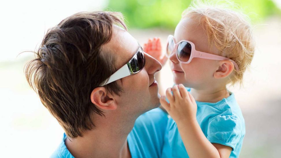 Vater und süße Tochter schauen sich mit Sonnenbrille in die Augen (Quelle: imago/McPHOTO)