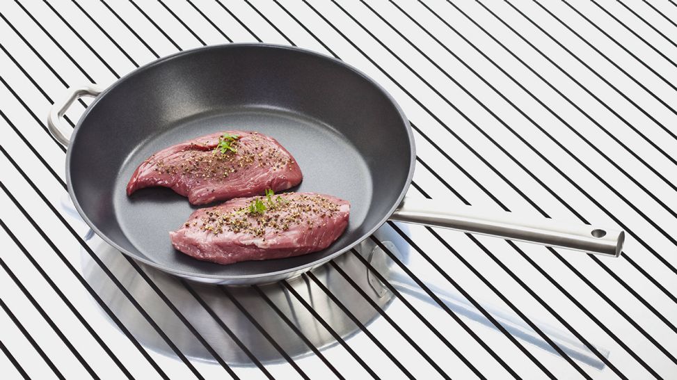 Ein rohes Steak liegt ohne Zugabe von Fett in einer beschichteten Bratpfanne (Quelle: imago/Westend61)