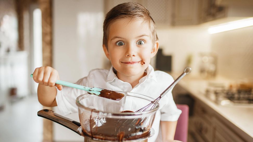 Kind beim Schokolade naschen in Küche (Bild: imago images/Panthermedia)