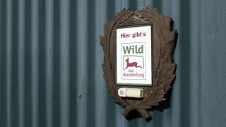 Das Schild eines Händlers für Wildfleisch an einer Hausfassade (Quelle: imago images/Steinach)