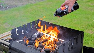 Ein Mann kippt Grillanzünder auf brennende Kohle in einem Grill (Quelle: IMAGO / Gottfried Czepluch)