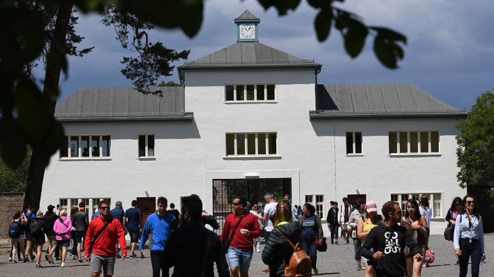 Besucher gehen am 16.06.2017 in Oranienburg (Brandenburg) vor dem Kommandanturgebäude des früheren KZ Sachsenhausen. (Quelle: dpa/Ralf Hischberger)