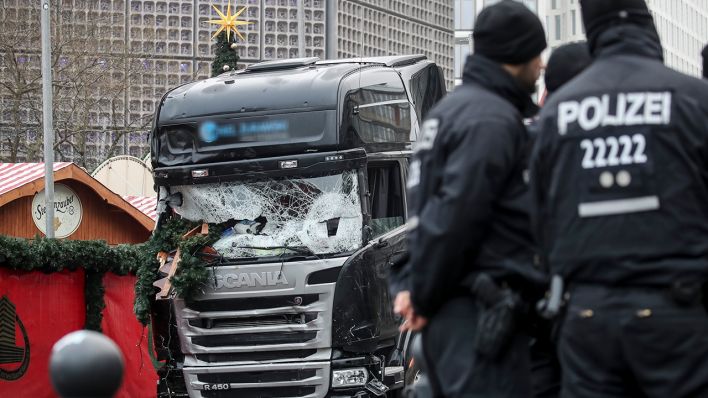 Polizisten stehen vor dem zerstörten LKW am 20.12.2016 am Weihnachtsmarkt am Breitscheidplatz in Berlin. (Quelle: dpa/Michael Kappeler)
