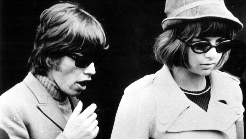 Mick Jagger und Chrissie Shrimpton landen nach einem Urlaub um 1965 in London. (Quelle: Imago Images/Topfoto )