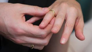 Symbolbild:Eine Hand steckt einer anderen einen Ring an den Finger.(Quelle:picture alliance/dpa/A.Warnecke)