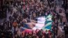 Teilnehmer tragen am 31.12.2023 bei einer Propalästinensischen Demonstration am Kottbusser Tor in Berlin Kreuzberg eine riesige palästinensische Flagge. (Quelle: dpa/Michael Kappeler)