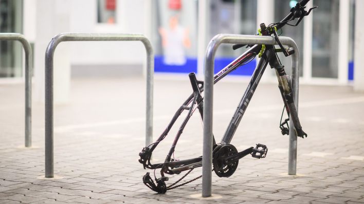 Symbolbild: Ein Fahrradrahmen mit diversen fehlenden Einzelteilen wie Reifen und Sattel steht an einem Fahrradbügel. (Quelle: dpa/Stratenschulte)