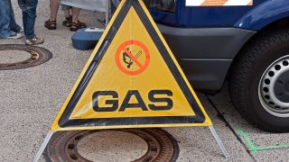 Ein Gas-Warndreieck steht vor einem Fahrzeug auf der Straße. (Quelle: imago-images/Zoonar)