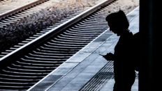 Symbolbild: Eine Frau steht am Berliner Bahnhof Ostkreuz am Bahnsteig und schaut auf das Handy. (Quelle: dpa/Christoph Soeder)
