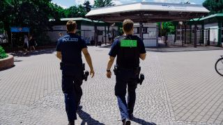 Archivbild: Zwei Polizsten der Mobilen Wache gehen auf das Prinzenbad in Kreuzberg zu. (Quelle: dpa/P. Zinken)