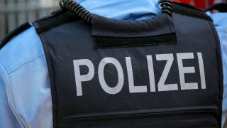 Symbolbild:Schriftzug Polizei auf einer Schutzweste in Nahaufnahme.(Quelle:picture alliance/M.Koch)