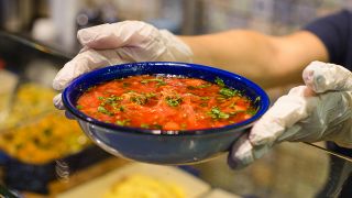 Hände halten einen Teller mit Suppe, Foto: Colourbox