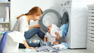 Mutter mit Kind vor der Waschmaschine, Foto: Colourbox