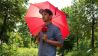 Chris Guse auf der Pirsch, mit rotem Regenschirm (Quelle: Joroni Film, Michael Kappler)