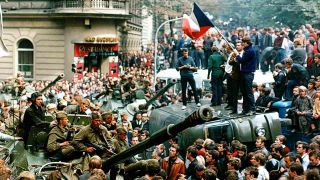 ARCHIV, Tschechoslowakei, Prag im August 1968: Protestierer umringen in der Innenstadt sowjetische Panzer und stehen mit einer Fahne der Tschechoslowakei auf einem umgekippten Militärfahrzeug (Bild: Libor Hajsky/CTK via epa/dpa)