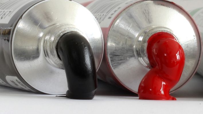 Illustration: Rot-schwarze Koalition - Ölfarben in schwarz und rot quellen aus Tuben heraus (Bild: dpa)