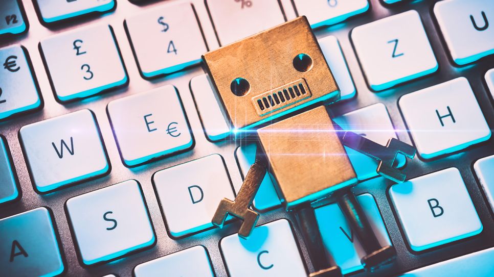 Roboterfigur auf einer Computertastatur; © dpa/CHROMORANGE/Christian Ohde