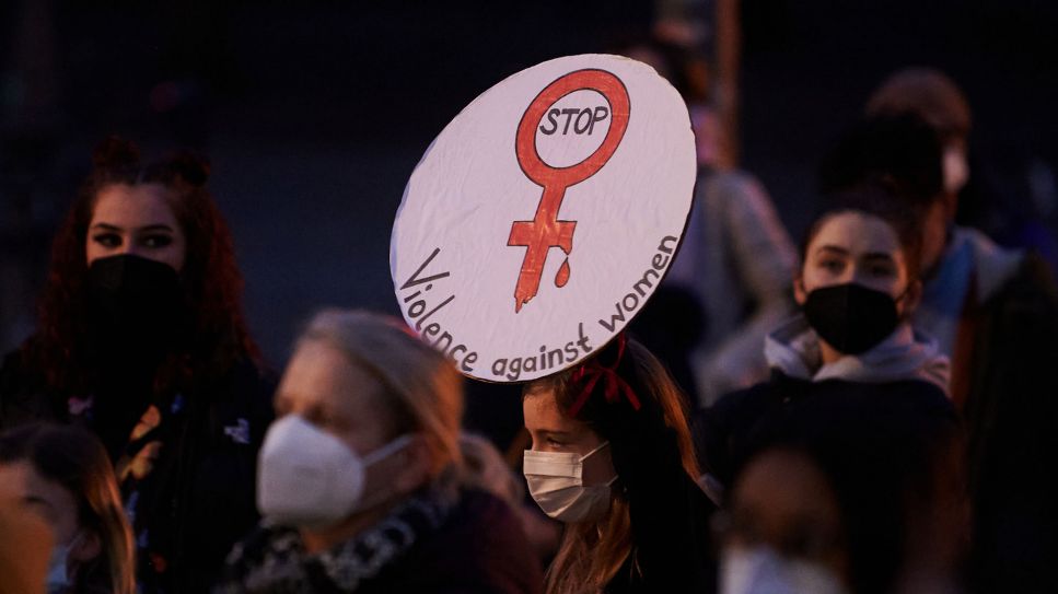 "Stop Violence against Women" ("Stop mit der Gewalt gegenüber Frauen") steht auf einem Plakat, das eine Demonstrantin vor dem Brandenburger Tor hält © dpa/Annette Riedl