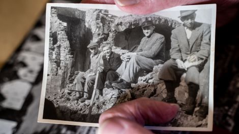 Krieg und Trauma – alte Hände halten ein Schwarzweiß-Foto aus der Nachkriegszeit; © dpa-Bildfunk