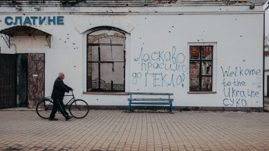 Mann mit einem Fahrrad geht an einem zerstörten Bahnhofsgebäude in Kharkiv vorbei, Foto: