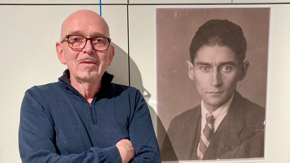 Hans-Gerd Koch steht neben einem Kafka Porträt in der Ausstellung "Das Fotoalbum der Familie Kafka" im Kulturwerk der Staatsbibliothek Unter den Linden © Anne-Dore Krohn