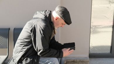 Kyjiw im Krieg: Mann liest Nachrichten am Smartphone © Yevgenia Belorusets