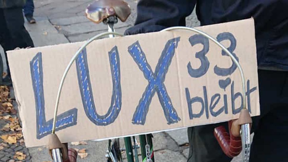 Der Investor: Moritz mit Fahrrad und Schild "Lux33 bleibt"; © Niklas Münch