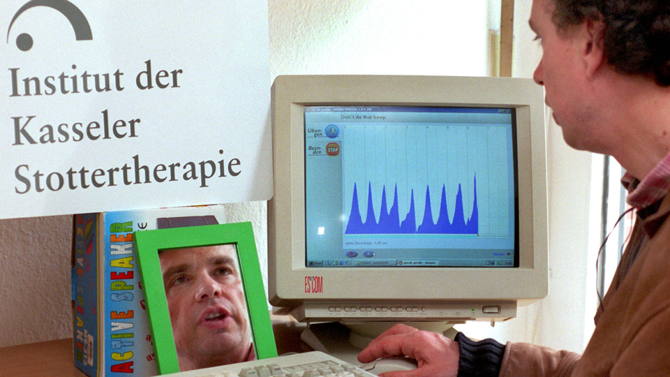 Der Mediziner Alexander Wolff von Gudenberg demonstriert ein für Stotternde angelegtes Computerprogramm, bei dem der Klient seine Stimmenkurve auf dem Bildschirm kontrollieren kann. Gleichzeitig kann er seine Mundbewegungen auf einem Spiegel beobachten; Foto: © dpa-Bildfunk