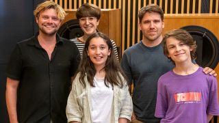 Team vom rbb-Kinderhörspiel "Hans im Glück 2.0" (2023), im Studio vor großen Lautsprecherboxen (Quelle: rbb/Oliver Ziebe)