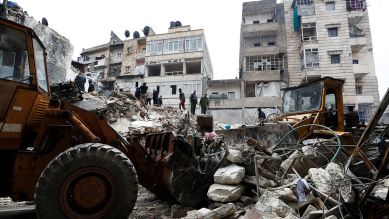 Mitarbeiter des syrischen Zivilschutzes und Sicherheitskräfte durchsuchen die Trümmer eingestürzter Gebäude in Aleppo, Syrien © AP Photo/Omar Sanadiki