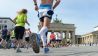 Viele Sportler laufen am 28.09.2014 beim 41. Berlin-Marathon nur weniger Meter vor der Ziellinie über den Pariser Platz in der Bundeshauptstadt (Quelle: dpa)