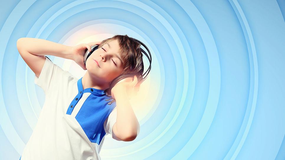 Ein Junge hat Kopfhörer auf und hört Musik (Quelle: Colourbox)
