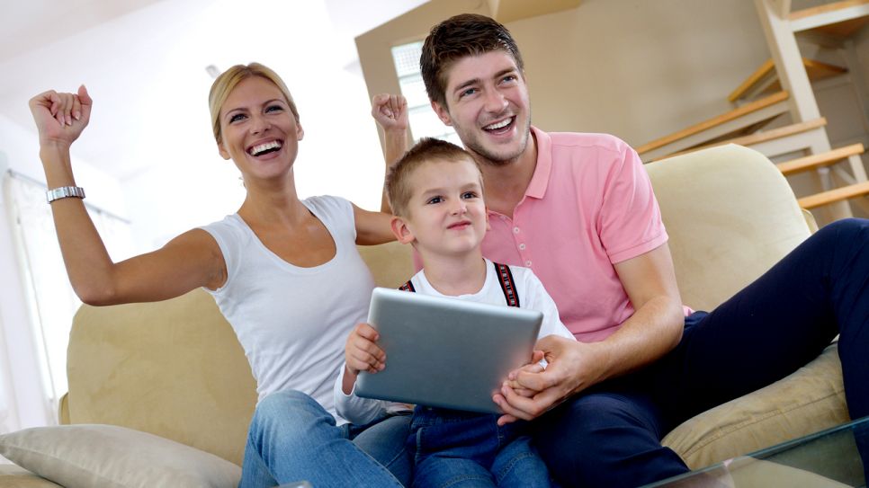 Eine Familie sitzt vor dem Fernseher mit einem Tablet und spielt bei zibb mit (Quelle: Colourbox)