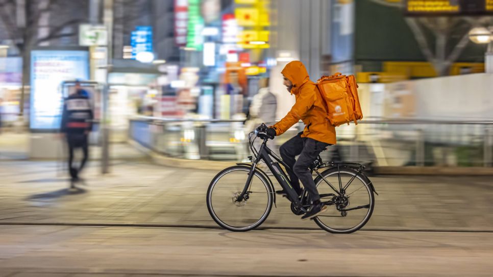 Essenslieferdienst auf einem Fahrrad (Quelle: IMAGO / Arnulf Hettrich)