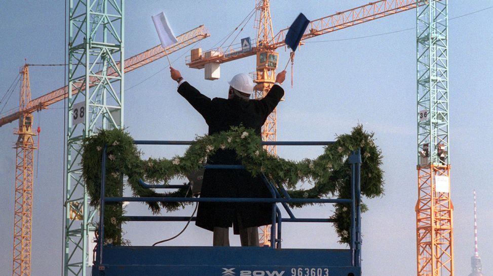 Daniel Barenboim dirigiert am 26.10.1996 beim Richtfest auf Europas größter innerstädtischer Baustelle auf dem Potsdamer Platz in Berlin das "Ballett der Kräne" (Bild: picture-alliance / dpa)
